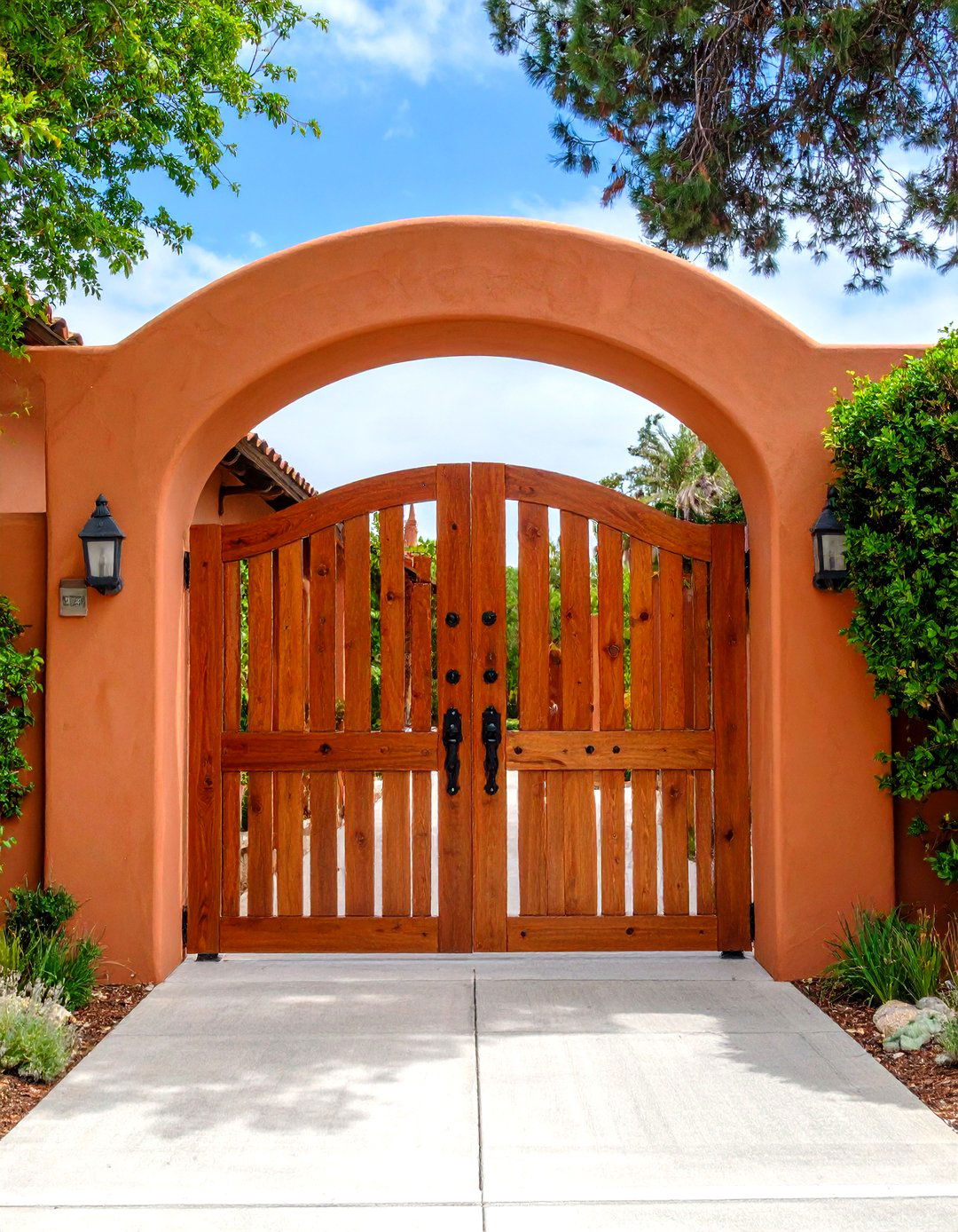 Stucco Wall with an Arched Wooden Gateway - 30 front yard fence ideas with driveway